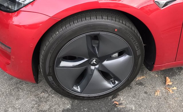Red Tesla Model 3 with aero wheels